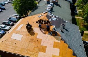 When to Repair vs. Replace Your Roof. Image of roofers working on the roof of a home.