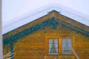 What is Snow Load? Image of a home with a pile of snow stacked on top of its roof.